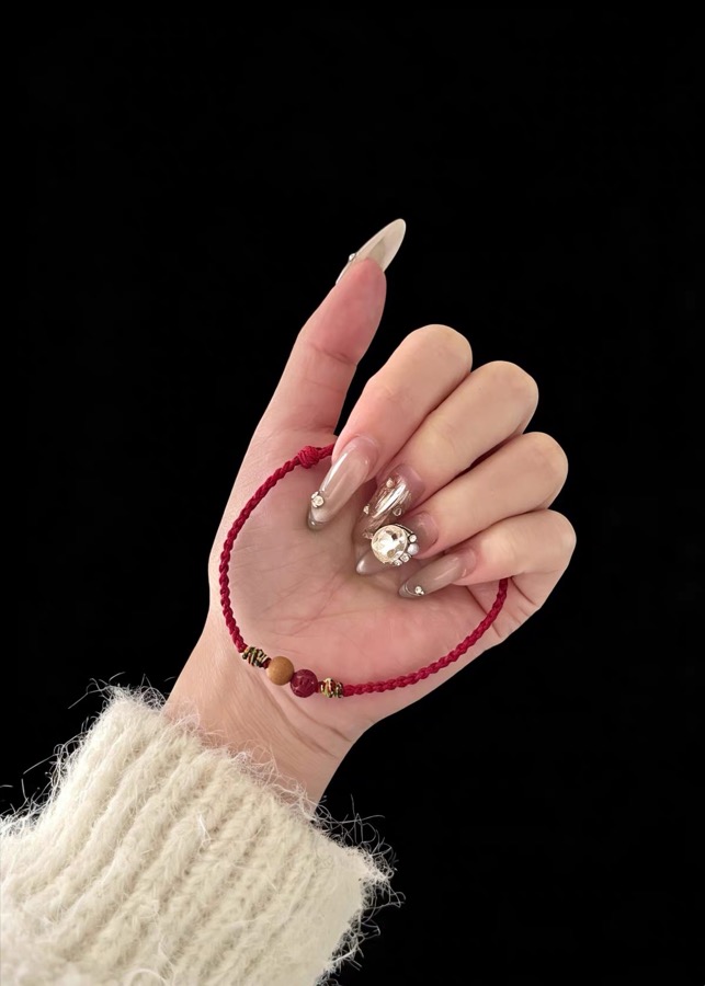 Customer-shared photo of a red string bracelet held in hand